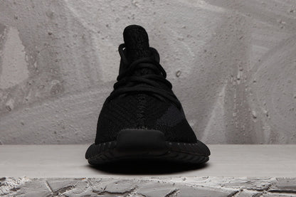 Front view of a black Yeezy 350 V2 sneaker showing the lace-up construction and rounded toe.