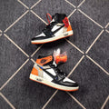 Pair of black, white, and orange Air Jordan 1 high-top sneakers displayed from the side with alternate orange laces.