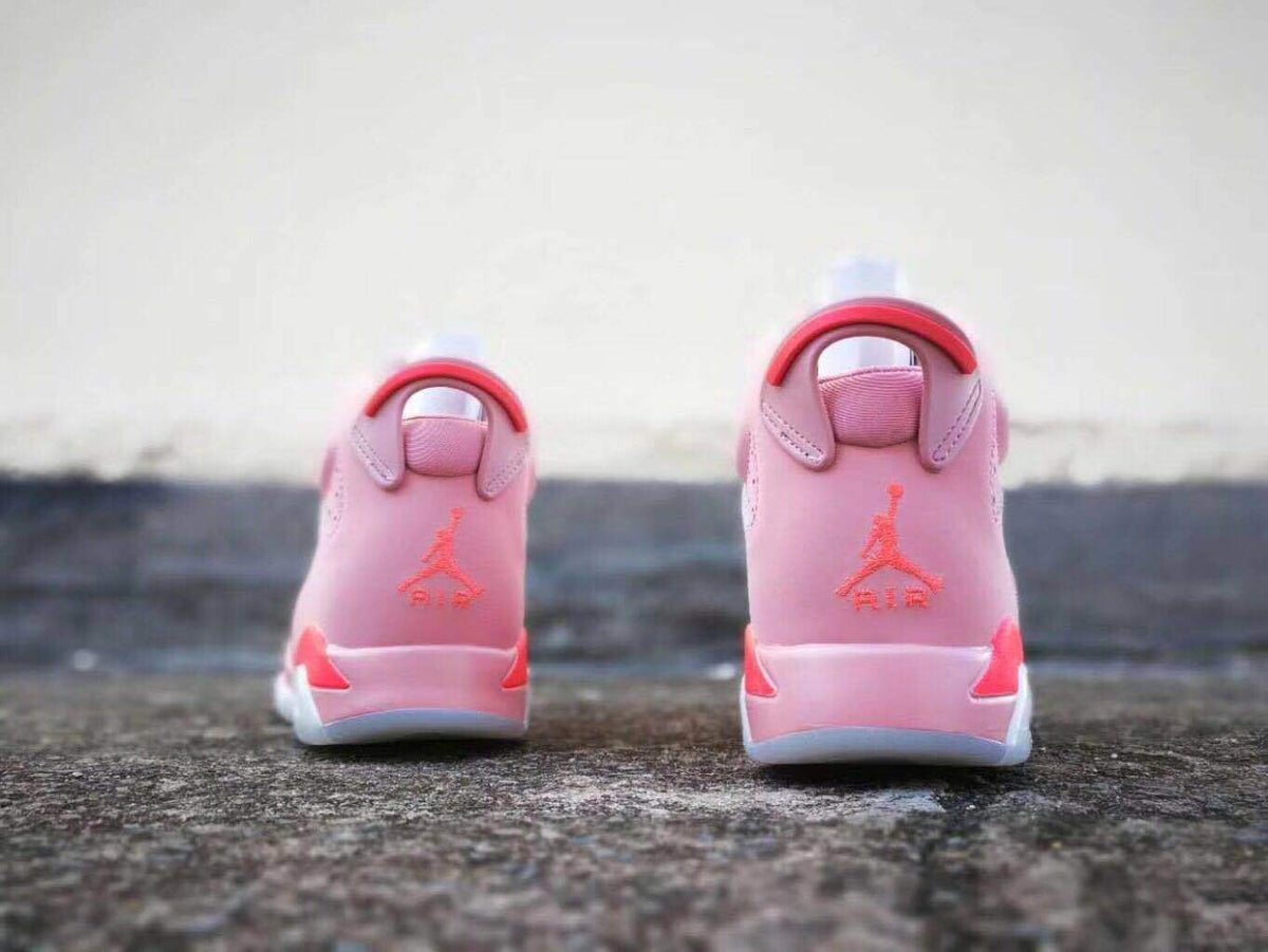 Rear view of the pink sneakers showing the heel pull tabs, Jordan branding, and red details.