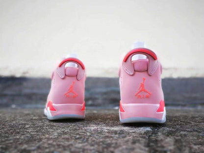 Rear view of the pink sneakers showing the heel pull tabs, Jordan branding, and red details.