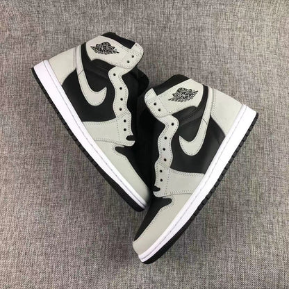 Pair of black and grey sneakers arranged diagonally on a textured surface.