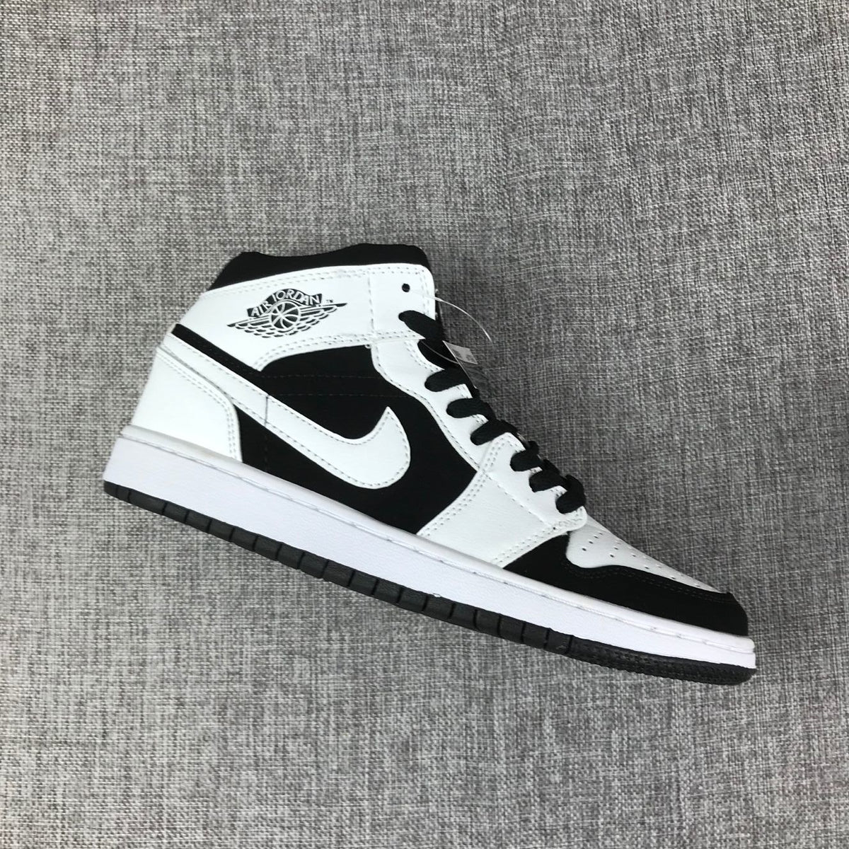 Single black-and-white high-top sneaker shown in side profile.
