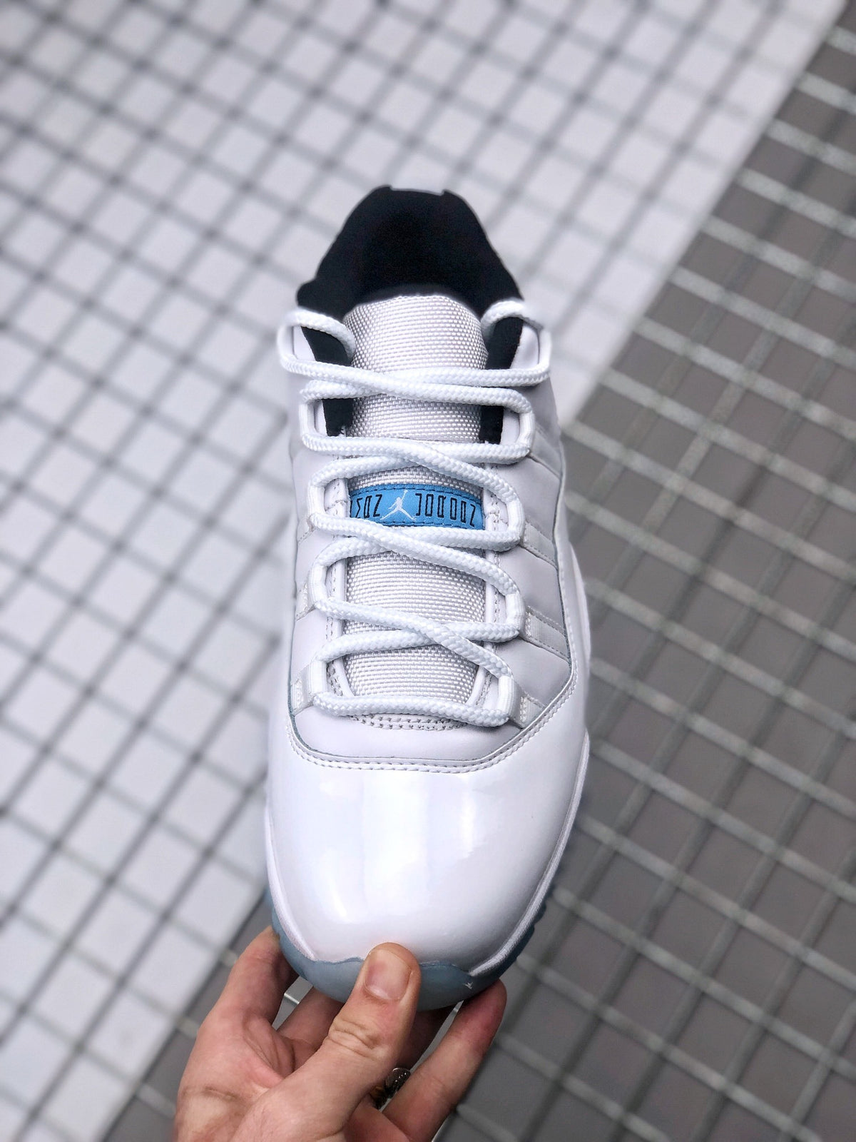 Top view showing the white laces, textured tongue, blue tongue label, and black collar lining.