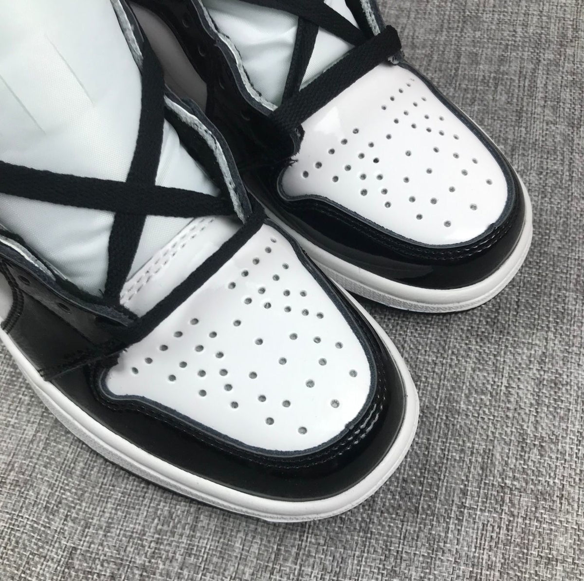 Close-up of the white perforated toe box and black overlay.