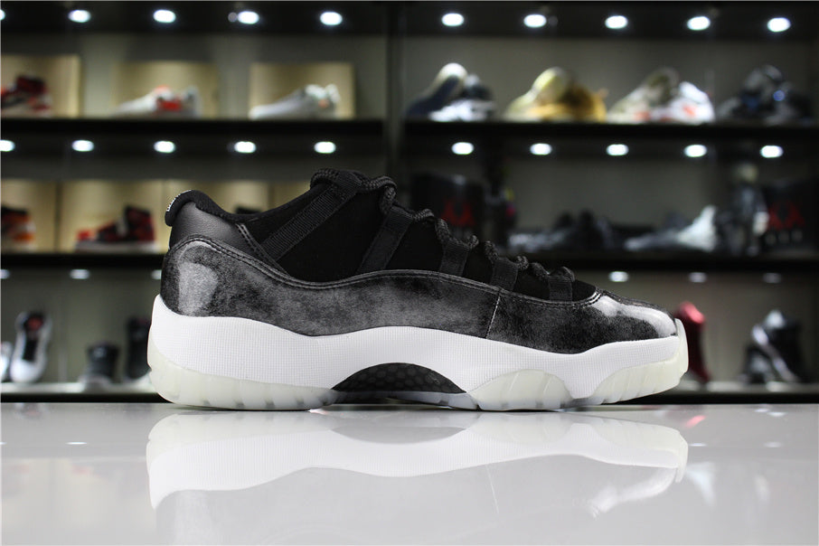 Side profile showing the low-top shape, black and silver upper, white midsole, and translucent outsole.