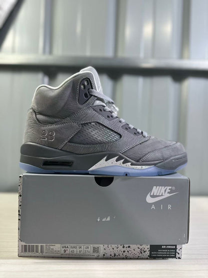 Side profile of a grey high-top sneaker displayed on its box; the box label visibly shows EU 43, US 9.5, UK 8, and CM 27.5.