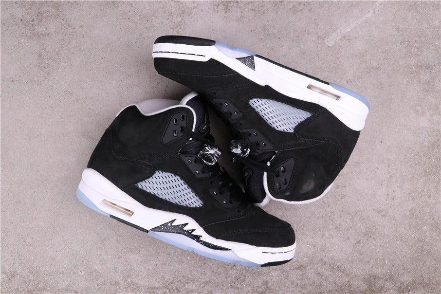 Pair of black and white sneakers arranged on their sides to show the lateral panels and midsoles.