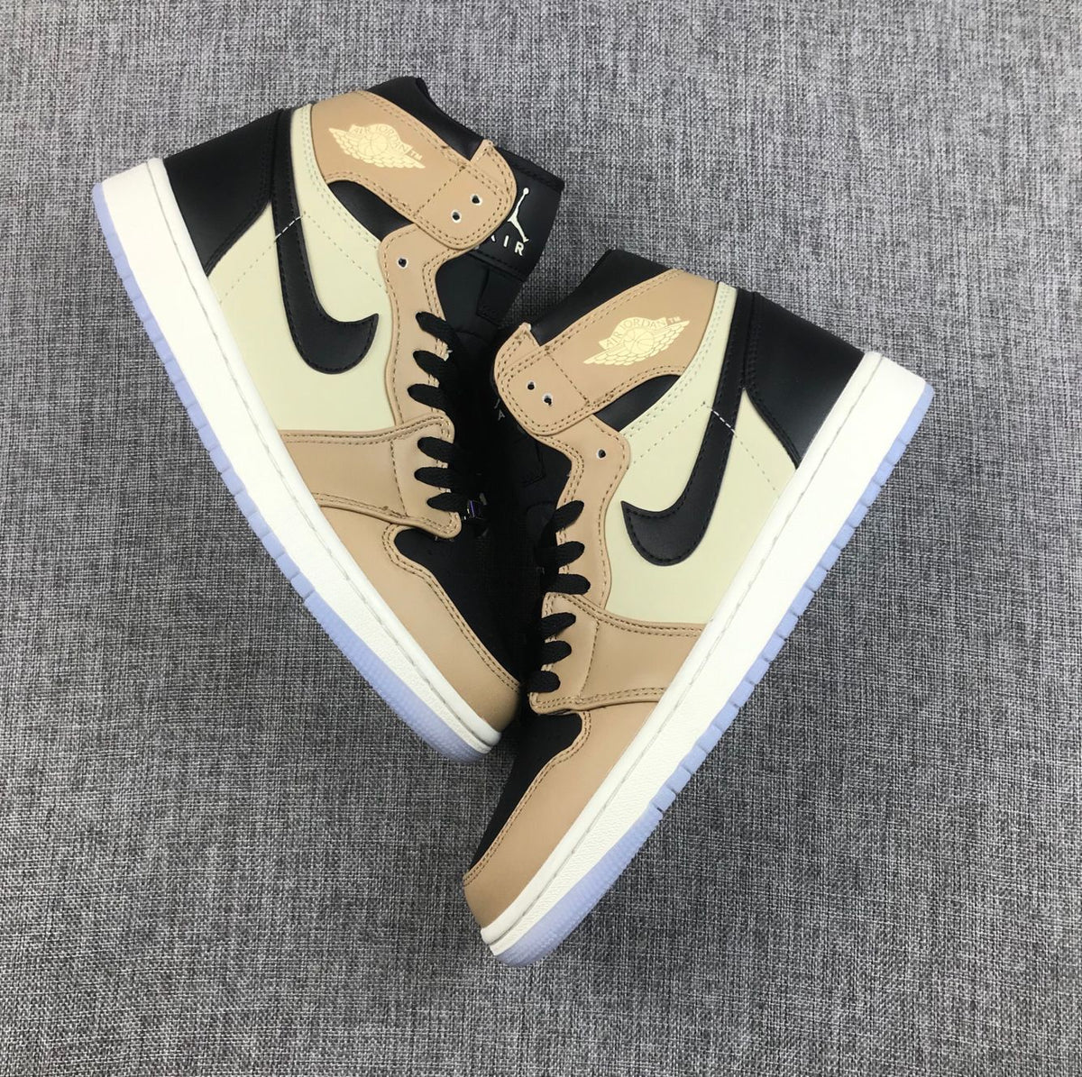 Pair of beige and black high-top sneakers arranged diagonally.
