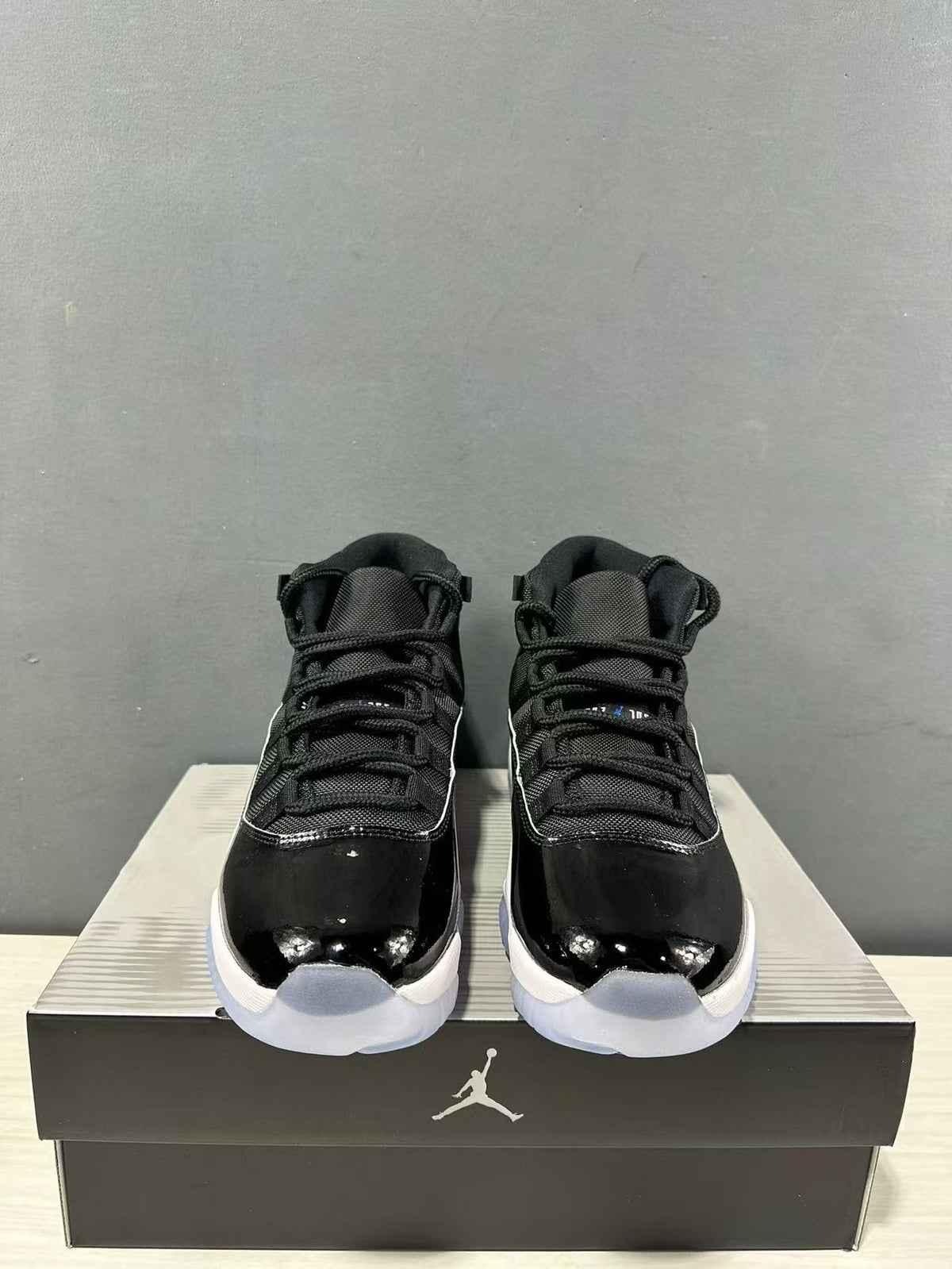 Front view of the pair showing the high-top collars, black laces, and glossy black toe sections.
