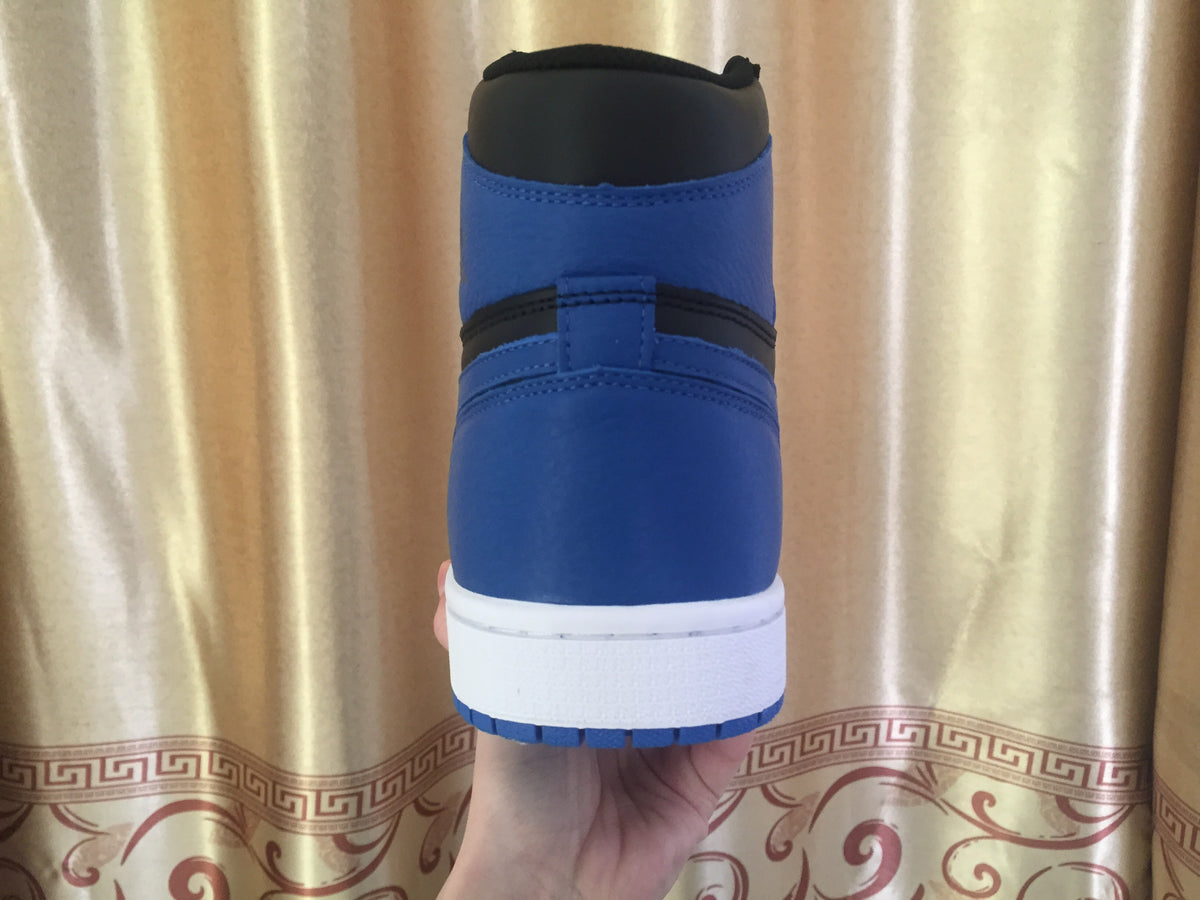 Rear view of one sneaker showing the blue heel panel, black collar and white midsole.