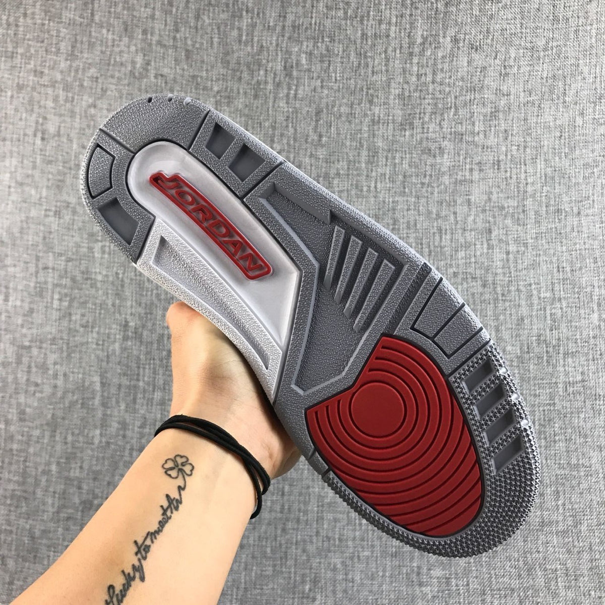 Outsole view showing the gray tread pattern and red circular traction section.