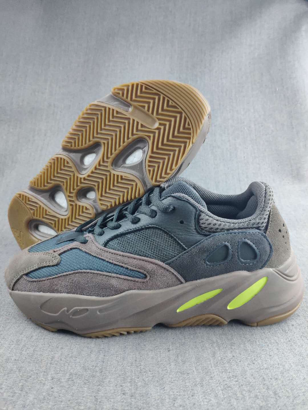 Side view of the gray and blue 700 sneaker showing the layered upper, sculpted sole, and gum-colored outsole.