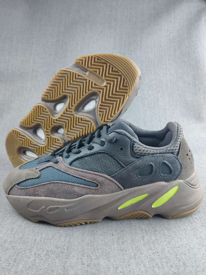 Side view of the gray and blue 700 sneaker showing the layered upper, sculpted sole, and gum-colored outsole.