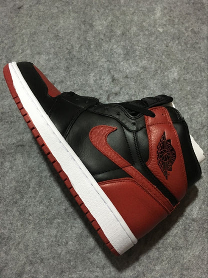 Angled side view highlighting the red ankle panel, black upper sections, Swoosh, and white midsole.