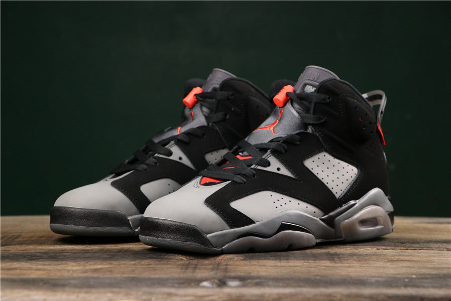 Three-quarter front view of the black and grey high-top sneakers with red accents.