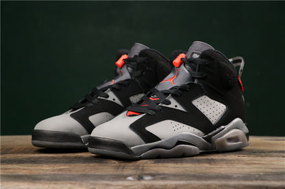 Three-quarter front view of the black and grey high-top sneakers with red accents.