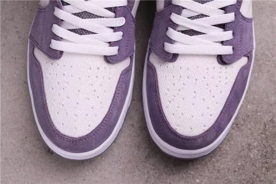 Close-up of the white perforated toe boxes with lavender overlays and white laces.