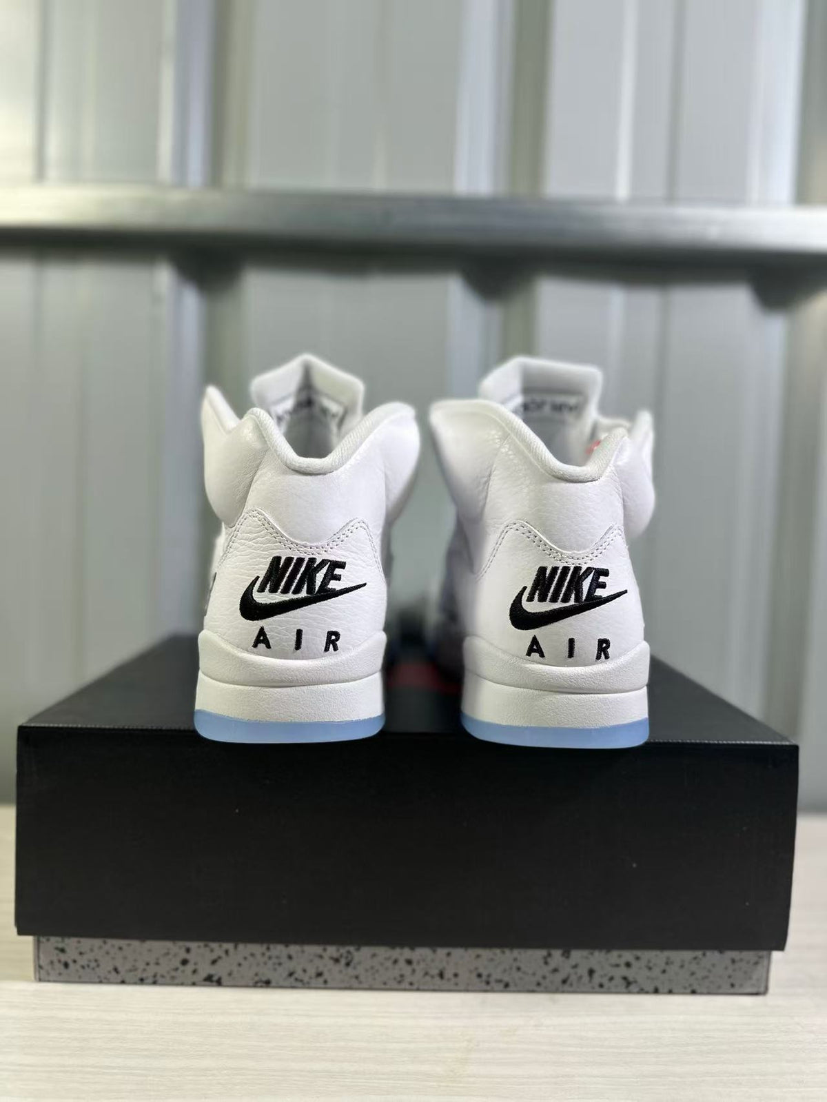 Rear view of the pair showing black Nike Air branding and translucent blue outsole edges.