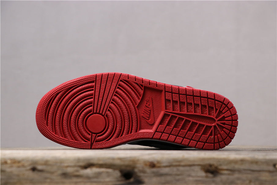 Side view of the red rubber outsole showing its circular forefoot and textured traction pattern.