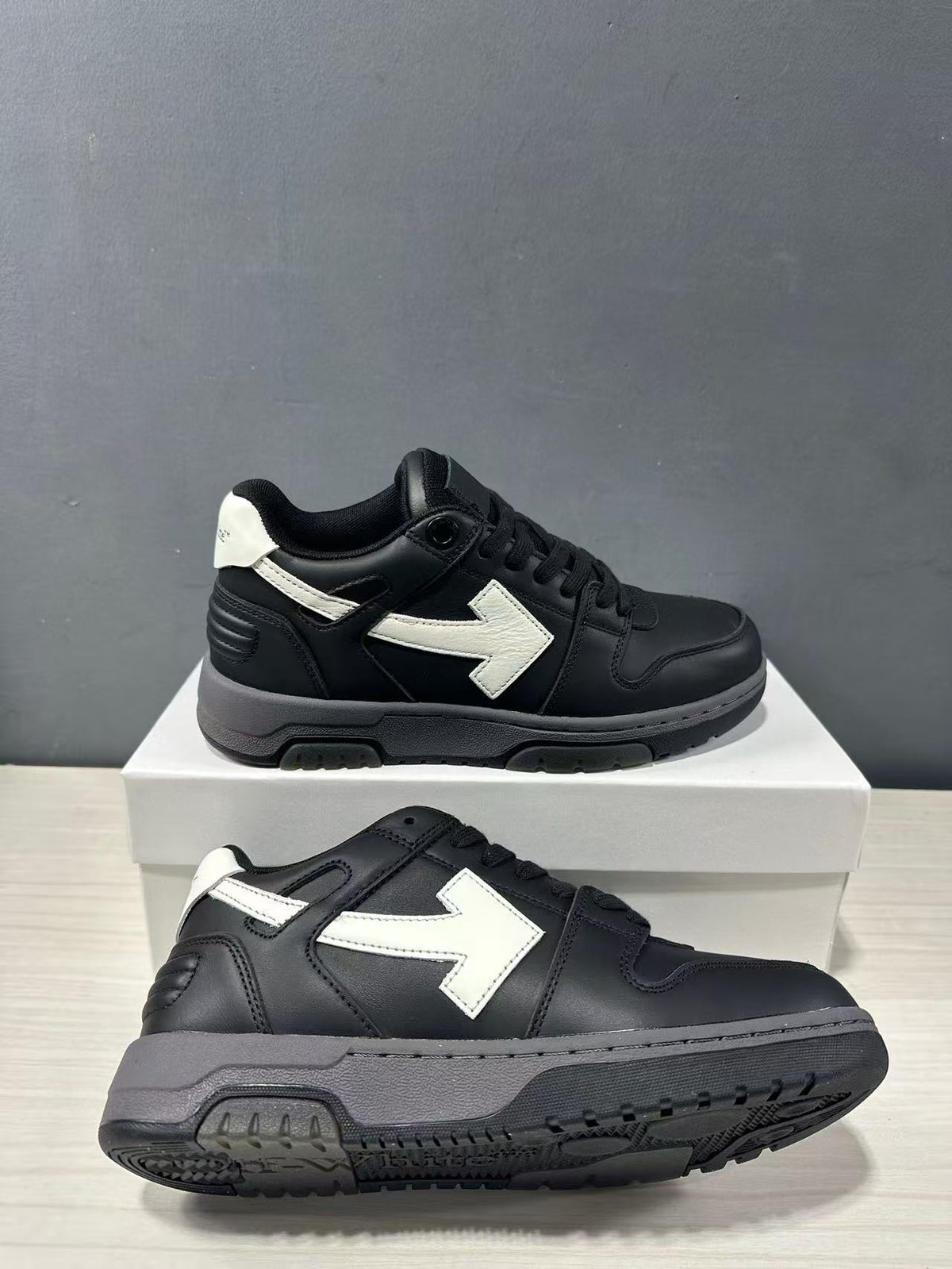 Pair of black and white low-top sneakers shown from side and outsole angles.
