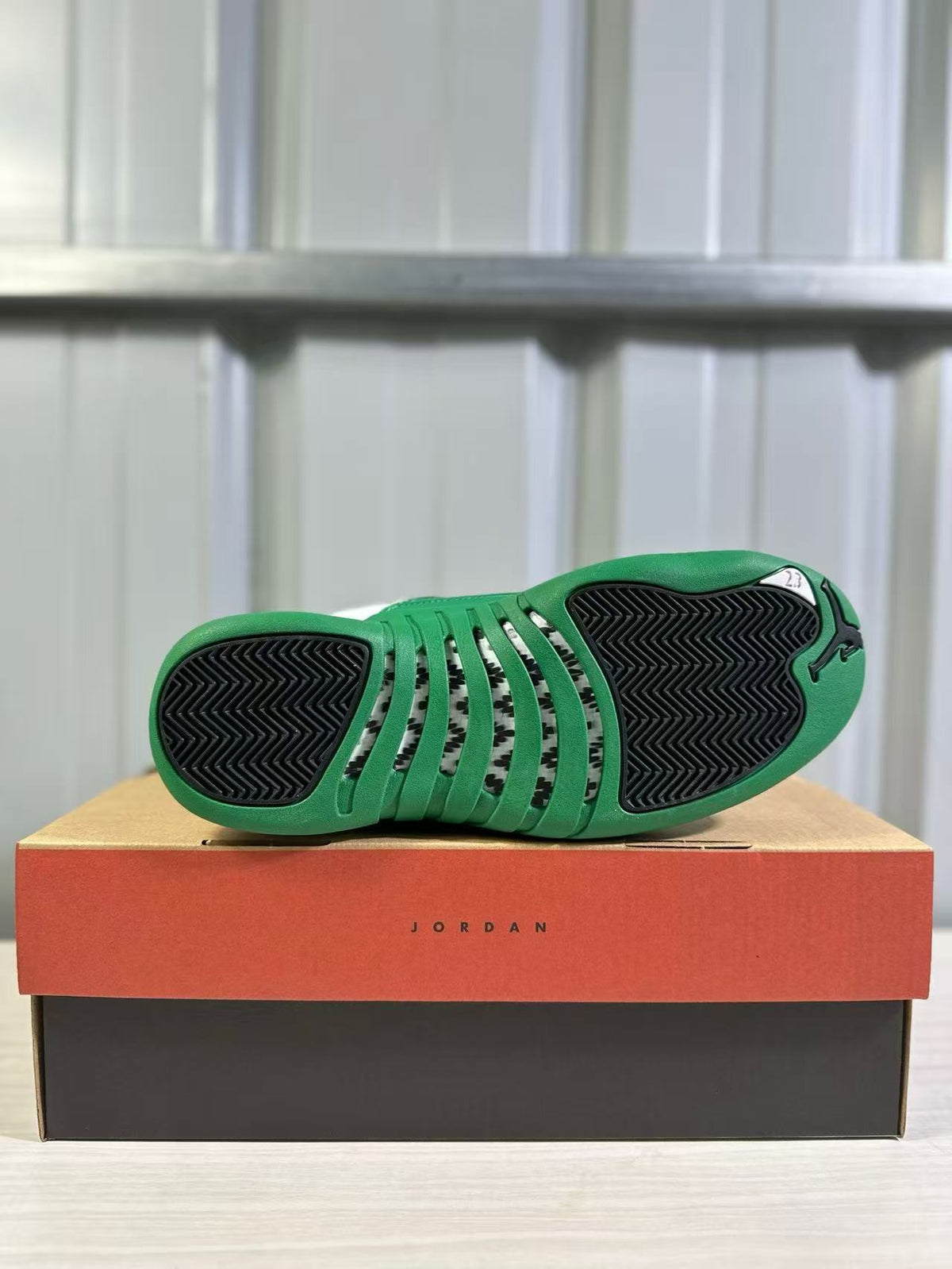 Bottom view showing the green outsole, black tread sections and central patterned area.