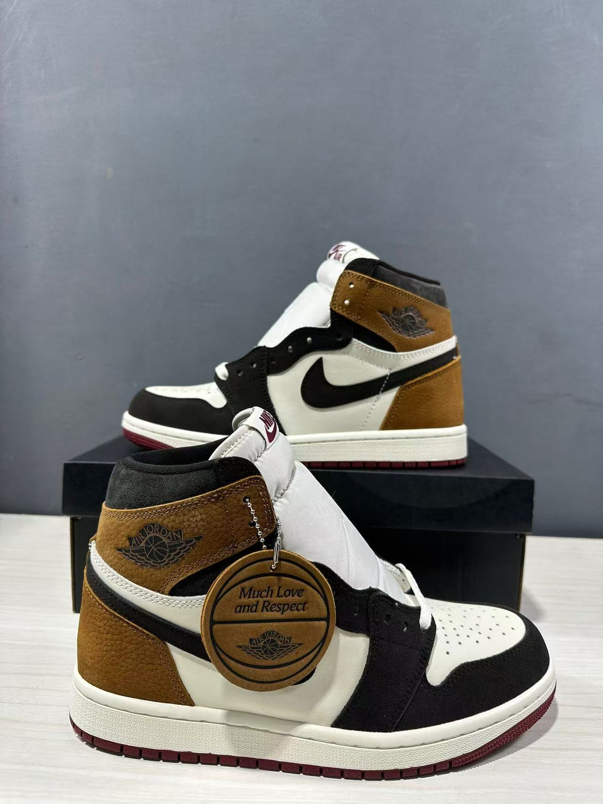 Close angled view of the pair showing the high-top construction and round “Much Love and Respect” hangtag.
