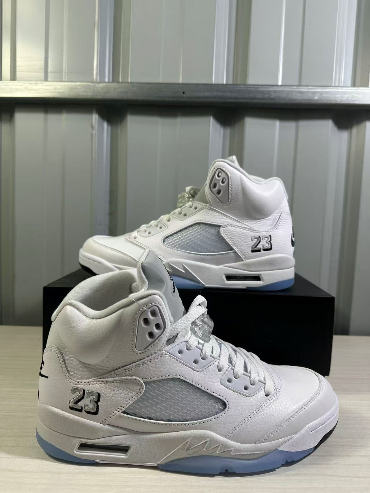 Close angled view of the white and silver sneaker pair with mesh panels and 23 details.