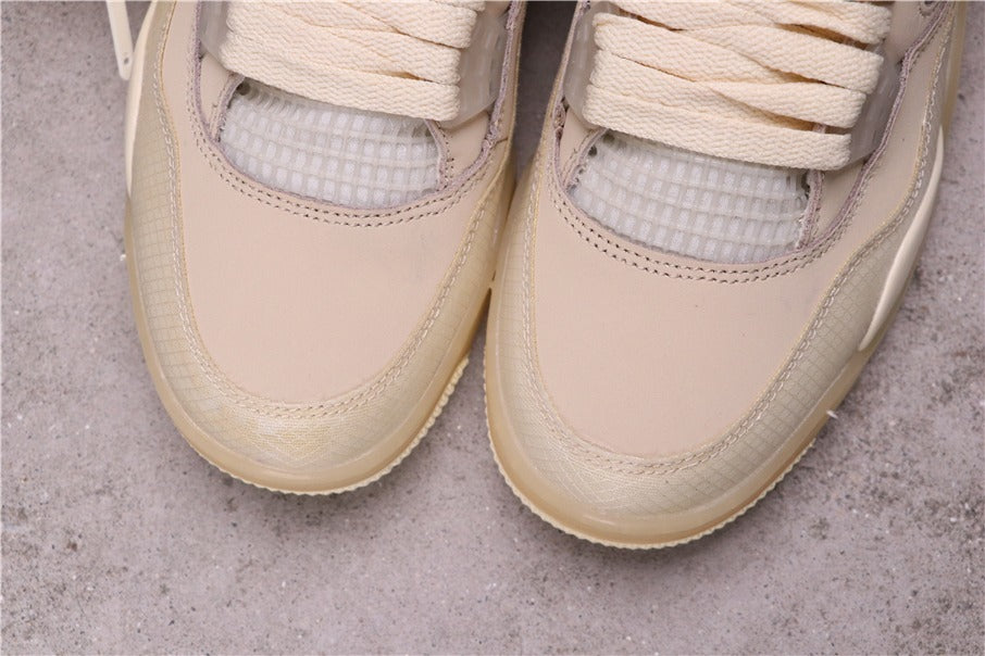 Close-up of the cream sneaker toe boxes, textured front overlays, stitching, and translucent mesh sections.