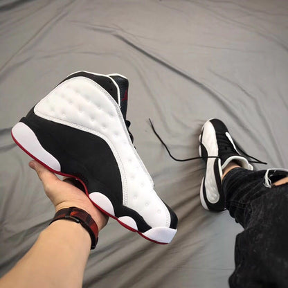 Top and side view showing the black toe, black laces, white side panels, and red outsole edge.