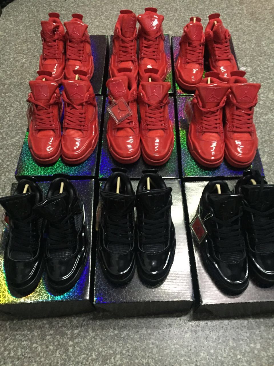 Multiple red and black high-top sneakers arranged on patterned boxes.