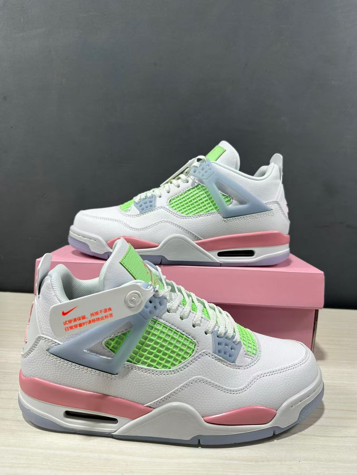 Angled product view showing both sneakers with white uppers, lime green side mesh, light blue supports, and pink midsole panels.