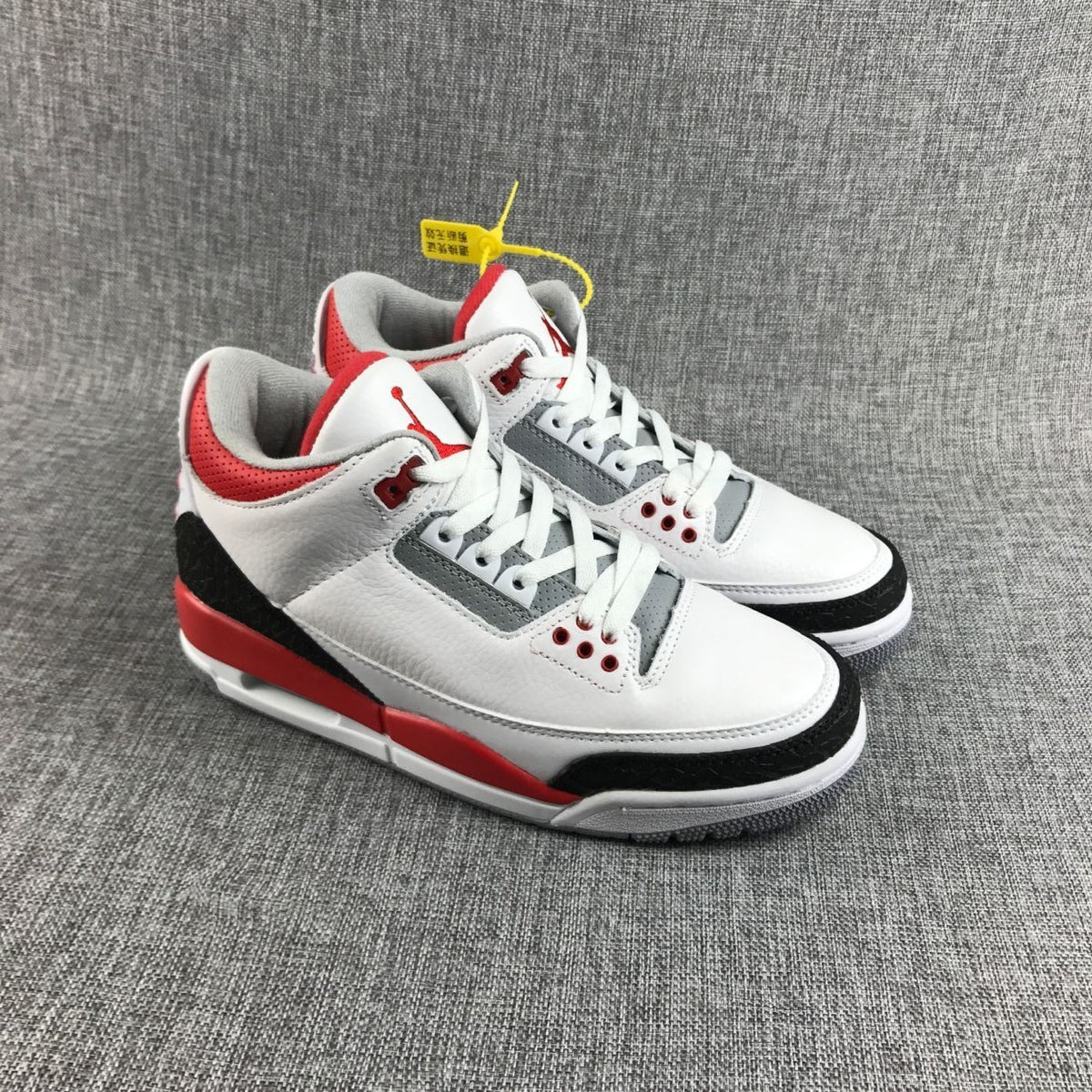 Front three-quarter view of the pair with white laces, red collar accents, and gray panels.