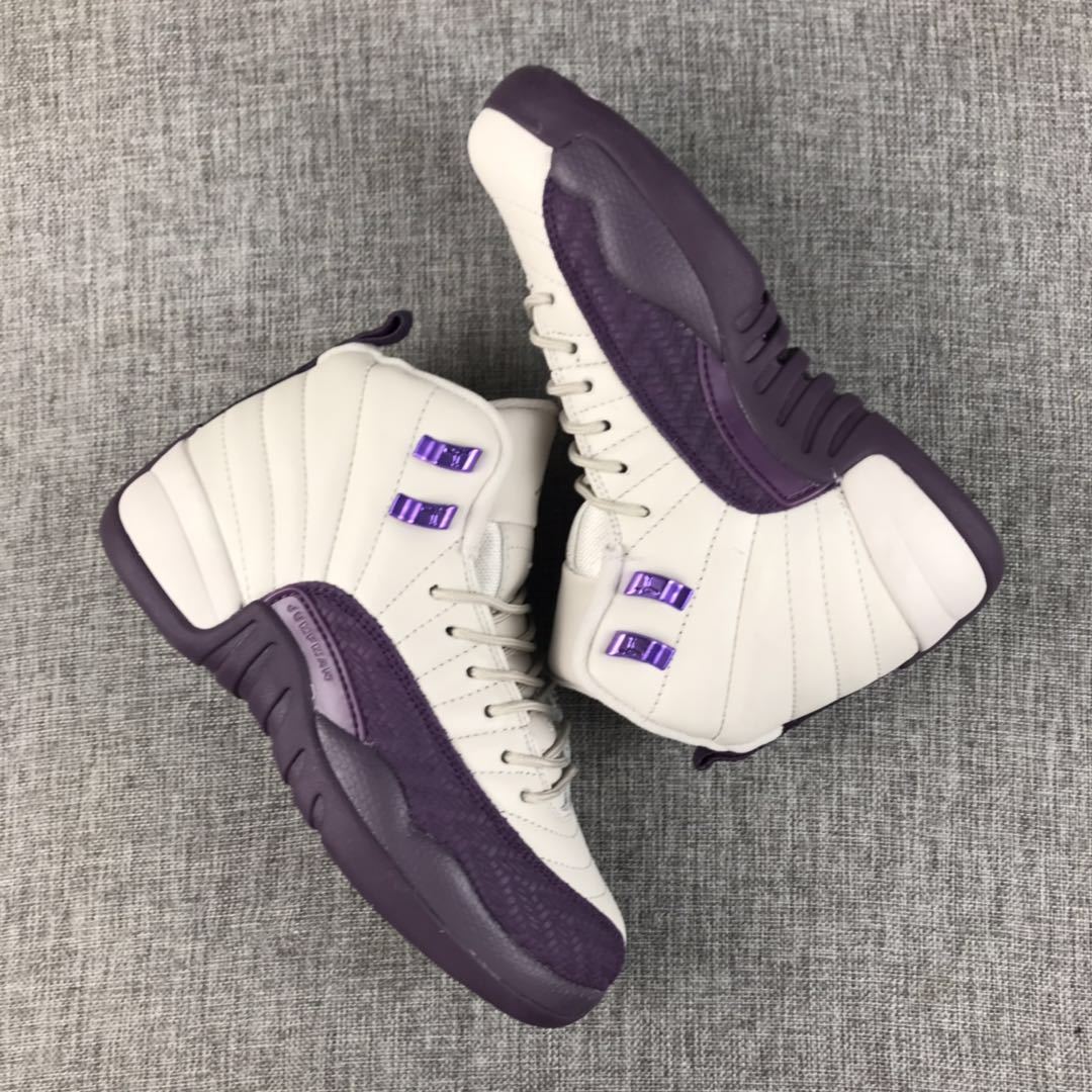 Pair of off-white and deep purple Air Jordan 12 high-top sneakers on a gray fabric surface
