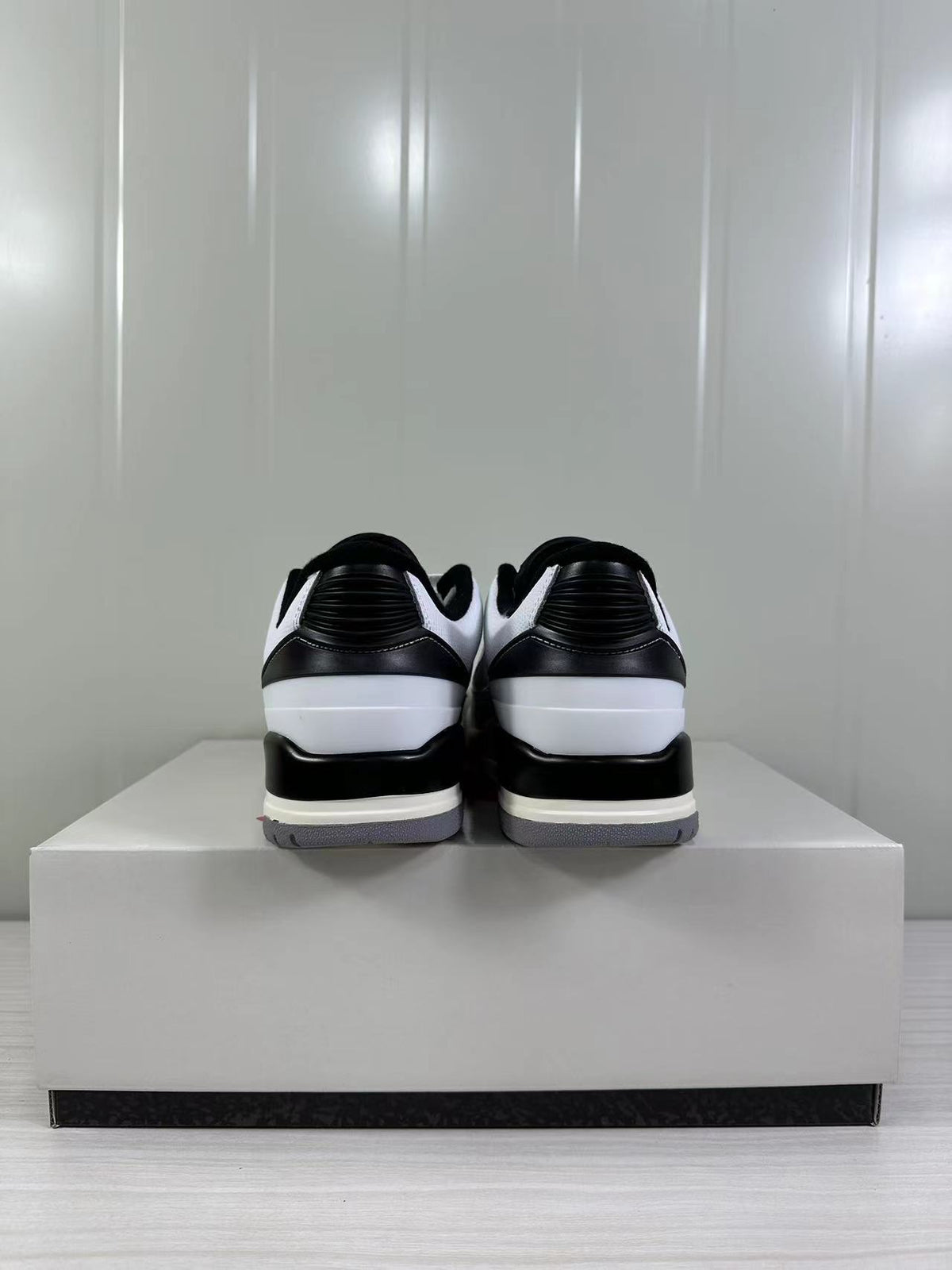 Rear view showing black padded collars, black heel panels, white heel sections, and gray outsoles.
