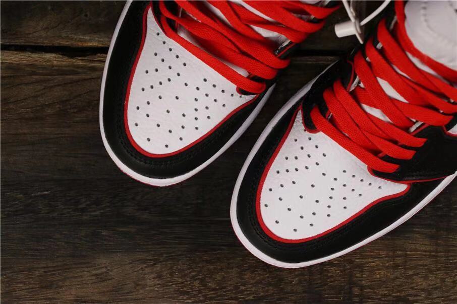 Close-up of the perforated white toe boxes with black overlays and red laces.