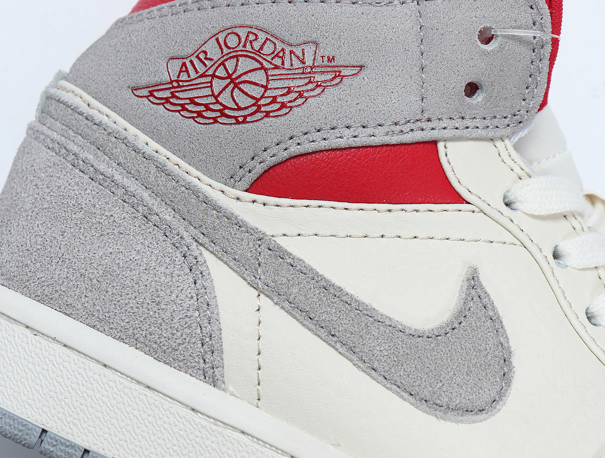 Close-up of the grey and white sneaker upper with a grey Swoosh, red panel and Air Jordan Wings branding.