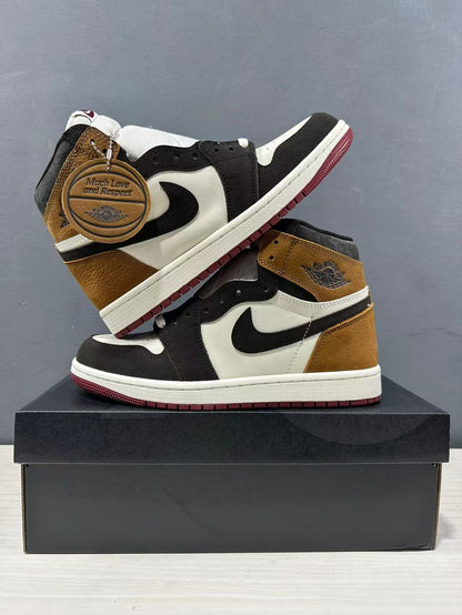 Pair of high-top sneakers displayed on a black shoebox, showing brown heel panels, black overlays and white midsoles.
