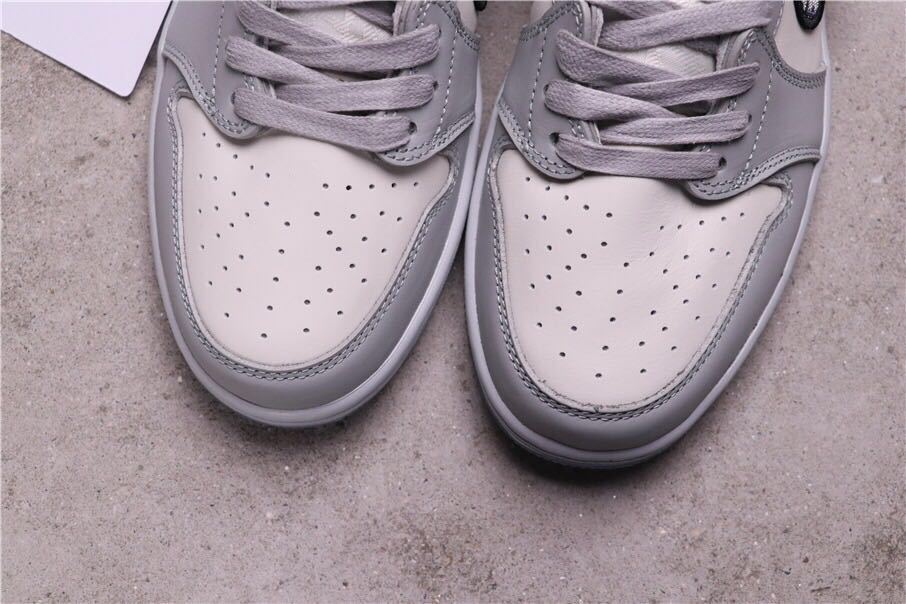 Close-up of the perforated light toe boxes and grey laces.