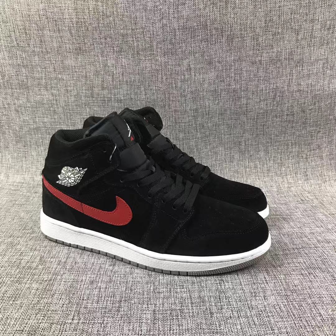 Three-quarter front view of the black high-top sneaker pair with red Swooshes and white midsoles.