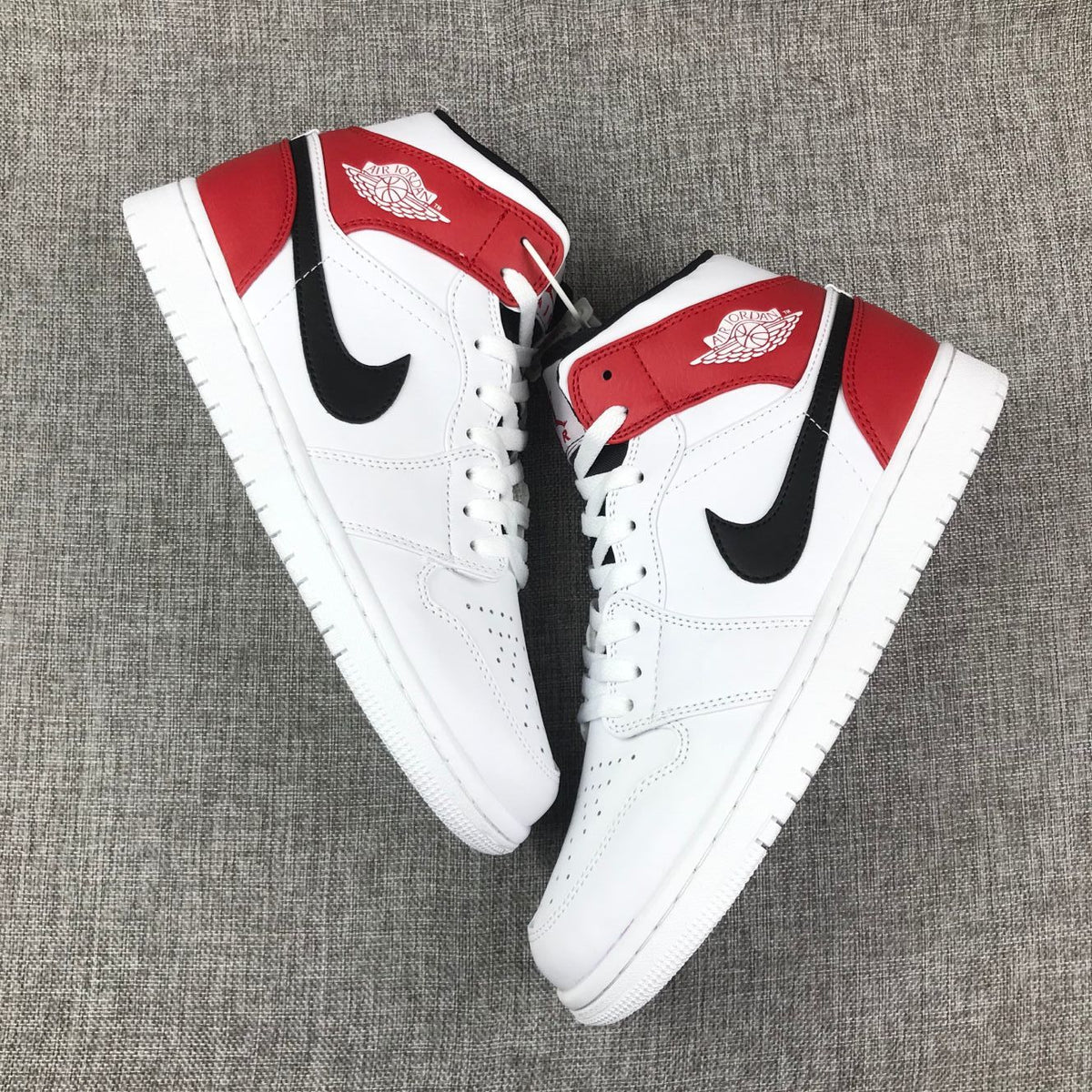 Top-down view of the pair displaying the white uppers, red overlays, and black side logos.