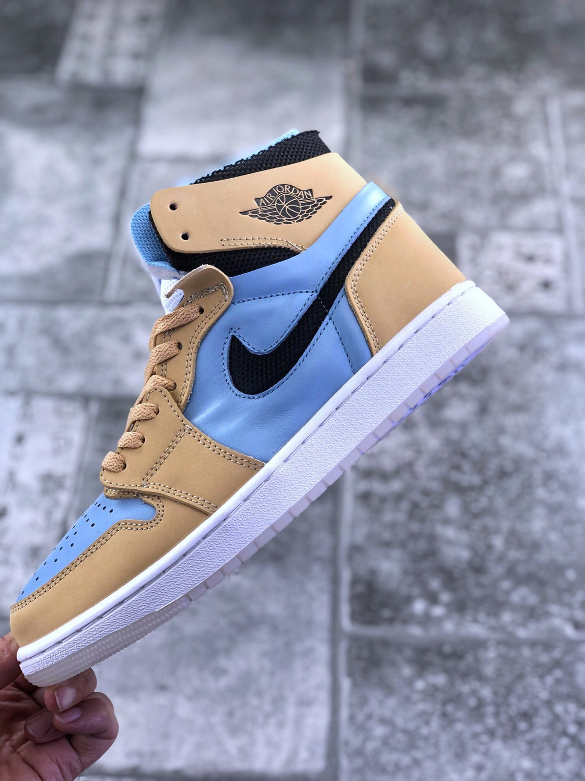 Side view highlighting the light blue quarter panel, black Swoosh, tan overlays, and white midsole.