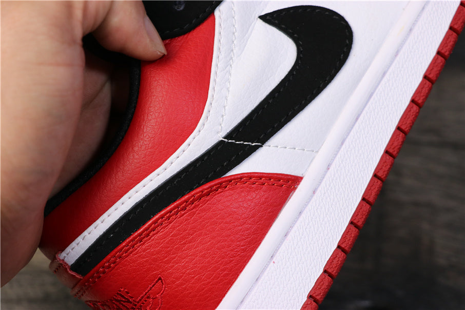 Close-up of the black Swoosh, white side panel, red heel panel, and white midsole.