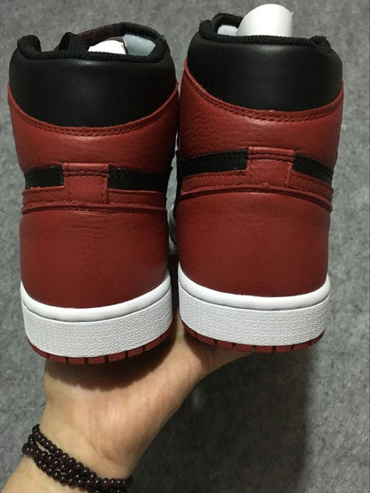 Rear view of black and red high-top sneakers with white midsoles and red outsoles.
