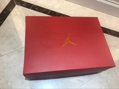 Closed red shoe box with a gold Jumpman logo.