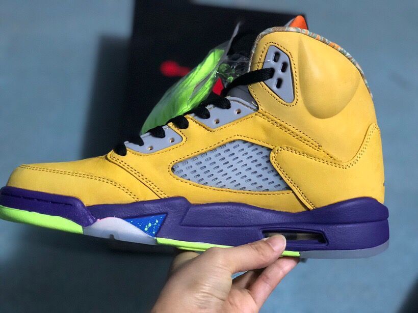 Side profile of the yellow high-top sneaker showing the mesh panel, purple midsole, and visible heel cushioning unit.
