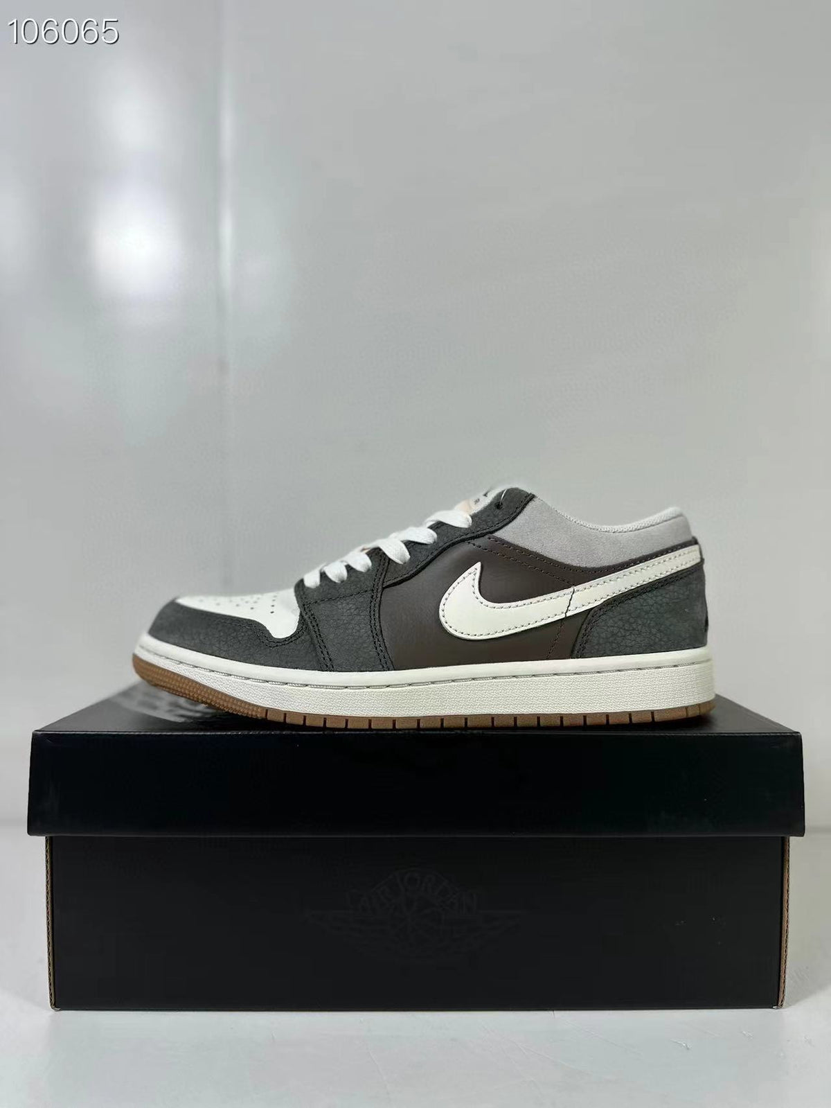 Side profile of a black, white and grey low-top sneaker with a white midsole and gum outsole.
