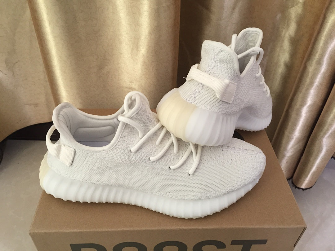 Side and rear view of the white sneakers showing the heel pull tabs and ribbed sole.