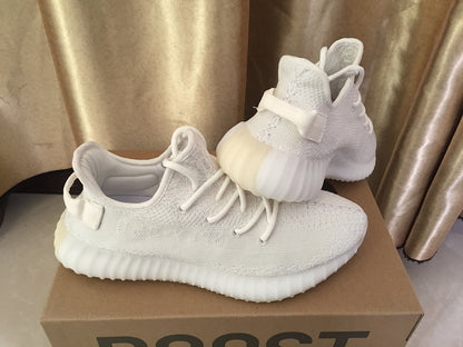 Side and rear view of the white sneakers showing the heel pull tabs and ribbed sole.