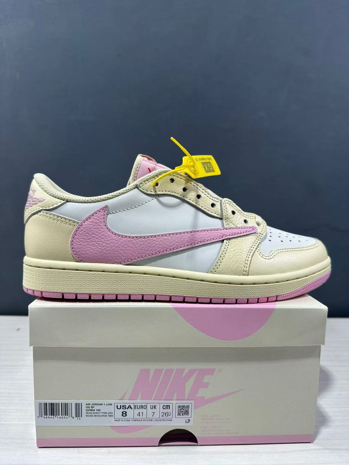 Side view of the cream, white and pink low-top sneaker displayed on its box; the box label shows EU 41.