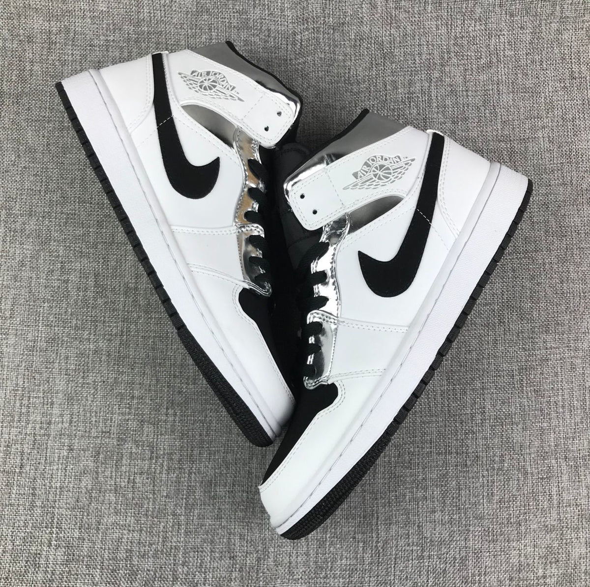 Top-down view of the pair displaying the white, black, and metallic silver color blocking.